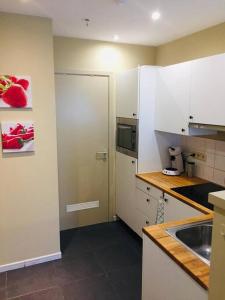 a kitchen with white cabinets and a sink at Toplocatie tussen Brussel en Antwerpen 4 personen in Meise