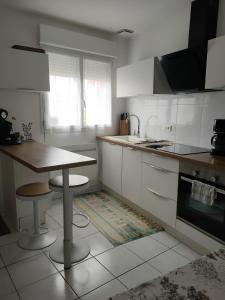 uma cozinha com armários brancos e uma mesa em Tresor de Beaurains em Beaurains