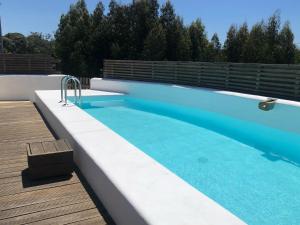 einen Pool neben einer Holzterrasse mit in der Unterkunft Casa Nascente - Casas de Seixe in Baiana + 34 Fotos