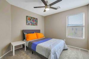 a bedroom with a bed and a ceiling fan at Jill's Goodyear Getaway in Goodyear