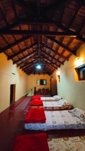 um quarto com uma fila de camas com cobertores vermelhos em Heritage Homestay em Chikmagalūr