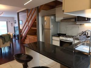 a kitchen with a black counter top and a refrigerator at Quintaluna ski y playa. in San Carlos de Bariloche