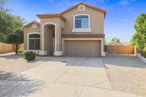 a large house with a garage in a driveway at Jill's Goodyear Getaway in Goodyear