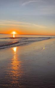 einen Sonnenuntergang am Strand mit dem Meer in der Unterkunft APARTAMENTO DE AMY CON VISTA AL MAR 2 in Huelva