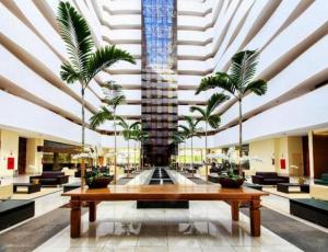 eine Lobby mit einem Brunnen mit Palmen in der Unterkunft Le Jardin in Caldas Novas