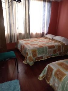 Hostal Chimborazo في Corona: غرفة نوم بسريرين ونافذة