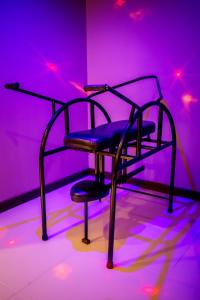 una sedia nera in una stanza con luci viola di Motel I Love Pelotas a Pelotas