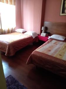 um quarto de hotel com duas camas e uma janela em Hostal Chimborazo em Corona