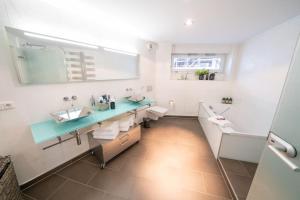 a bathroom with a sink and a toilet and a mirror at NEW Schöne Eigentumswohnung im Zentrum von Deggendorf in Deggendorf