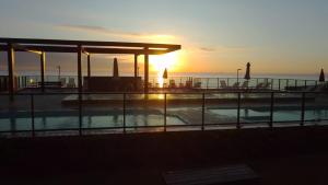 una piscina con puesta de sol en el fondo en Apartamento pé na areia en Barra Velha