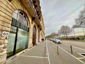 budynek po stronie ulicy z zaparkowanymi samochodami w obiekcie Appartement Le Médicis - 2 chambres w Rouen