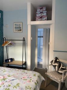 a bedroom with a bed and a chair and a window at The Rosefield in Weymouth