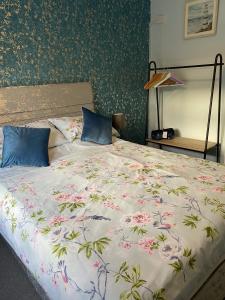 a bedroom with a bed with a floral bedspread at The Rosefield in Weymouth