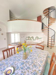 a dining room table with a vase of flowers on it at Euploia Apartment in Ischia