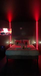 a bedroom with a bed with red lights on it at L’Évasion - Chambre & Jacuzzi in Obigies