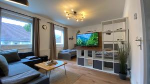 uma sala de estar com um sofá e uma televisão em CHARLIE , Solingen Mitte, Ferien/Messe Wohnung für bis zu 5 Personen em Solingen