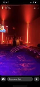 a room with a swimming pool with a tv and lights at L’Évasion - Chambre & Jacuzzi in Obigies