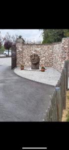 a brick wall with a statue of a face at L’Évasion - Chambre & Jacuzzi in Obigies