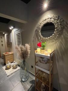 a room with a mirror and a shelf with flowers at L’Évasion - Chambre & Jacuzzi in Obigies