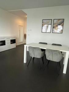 einen weißen Tisch und Stühle in einem Zimmer in der Unterkunft Luxuswohnung direkt am Phönixsee in Dortmund