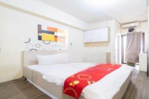 um quarto com uma cama com um cobertor vermelho em OYO 93761 Kemang View By Room 88 em Bekasi