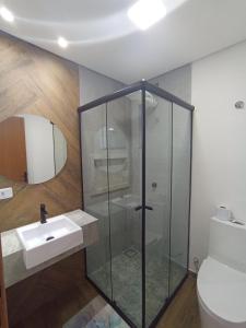 W łazience znajduje się szklana kabina prysznicowa i umywalka. w obiekcie Studio 23 vista para o mar w mieście Pontal do Paraná