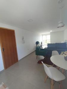 ein Wohnzimmer mit einem Sofa, einem Tisch und Stühlen in der Unterkunft Studio 23 vista para o mar in Pontal do Paraná