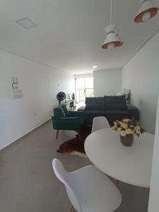 sala de estar con sofá, mesa y sillas en Studio 23 vista para o mar en Pontal do Paraná