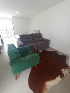 sala de estar con sofá y alfombra en Studio 23 vista para o mar en Pontal do Paraná