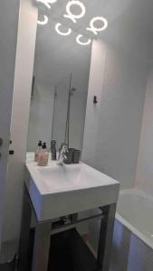 een witte badkamer met een wastafel en een spiegel bij Casa Maria in Lagos