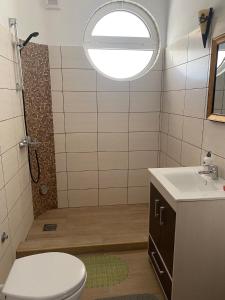 baño con aseo y ducha con ventana en Jasmina Apartments, en Ulcinj
