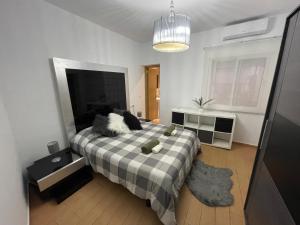 sypialnia z łóżkiem z kocem szachowym w obiekcie CASITA ANDALUZA CENTRO con PARKING sujeto a disponibilidad w Maladze