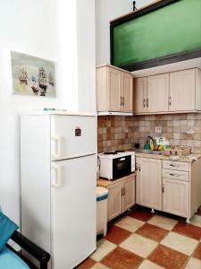 eine Küche mit einem weißen Kühlschrank und einem TV in der Unterkunft Villa Anna in Agios Petros