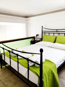 sypialnia z 2 łóżkami z zieloną i białą pościelą w obiekcie Villa Anna w mieście Agios Petros