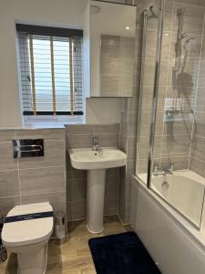 a bathroom with a toilet and a sink and a shower at A stunning 3 bed luxury holiday home in Buckinghamshire