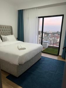 - une chambre avec un grand lit et une grande fenêtre dans l'établissement Dael luxury apartments, à Nairobi