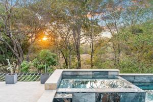 a pool of water with the sun in the trees at Brand-New 6BD Giant with Private Pool by SPCR in Potrero