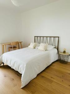 a large white bed with white sheets and pillows at Presqu'île, appartement neuf avec balcon, salle de gym et parking in Caen +15 photos