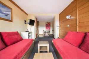 un salon avec des canapés rouges et une table dans l'établissement Résidence L'Ours Blanc - maeva Home - Appartement 3 pièces 7 personnes - Sélection MAE-8949, à Huez