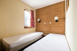 deux lits dans une petite pièce avec une fenêtre dans l'établissement Résidence L'Ours Blanc - maeva Home - Appartement 3 pièces 7 personnes - Sélection MAE-8949, à Huez