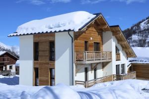 a cabin in the snow with a balcony at Les Chalets Du Grand Galibier - 4 Pièces pour 8 Personnes 94 in Valloire