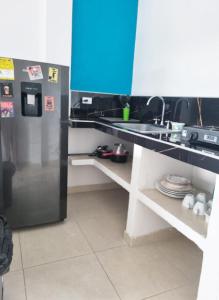 La cuisine est équipée d'un comptoir avec évier et d'un réfrigérateur. dans l'établissement Apartamento Privado Palomino, à Palomino