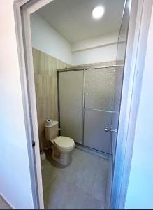 baño con aseo y puerta de ducha de cristal en Apartamento Privado Palomino en Palomino