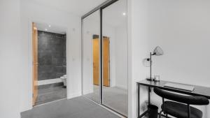 an office with a desk and a glass shower door at Axium Escape- 2 bed apartment, Birmingham City Centre in Birmingham