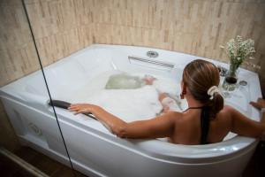 萊瓦鎮的住宿－Hotel Campestre La Periquera，坐在浴缸里满水的女人