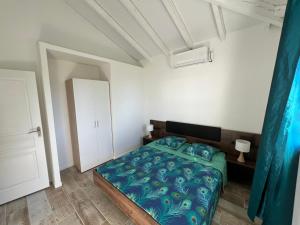 um quarto com uma cama com um cobertor azul em Villa OCEANE em Trois-Rivières