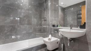 a bathroom with a sink and a toilet and a tub at Axium Escape- 2 bed apartment, Birmingham City Centre in Birmingham