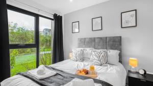 a bedroom with a bed with a tray of fruit on it at Axium Escape- 2 bed apartment, Birmingham City Centre in Birmingham