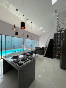 a kitchen with a stove and a swimming pool at Casa maria Júlia in Araguaína