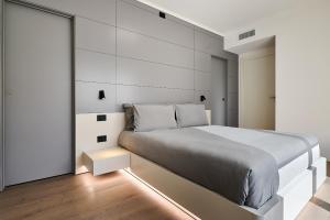 a bedroom with a large bed and a white wall at Design Villa in Tremezzina Villarnona Lake Como in Mezzegra